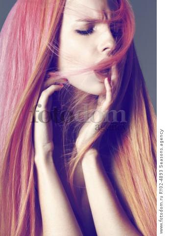 A young woman with long pink and orange hair