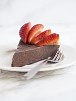 Slice of a flourless chocolate fudge cake with str