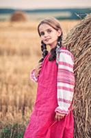 Девочка в русской народной одежде у стога сена