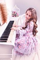 Девочка в розовом платье играет на пианино