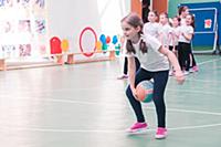 Девочка школьница прыгает с мячом на уроке физкуль